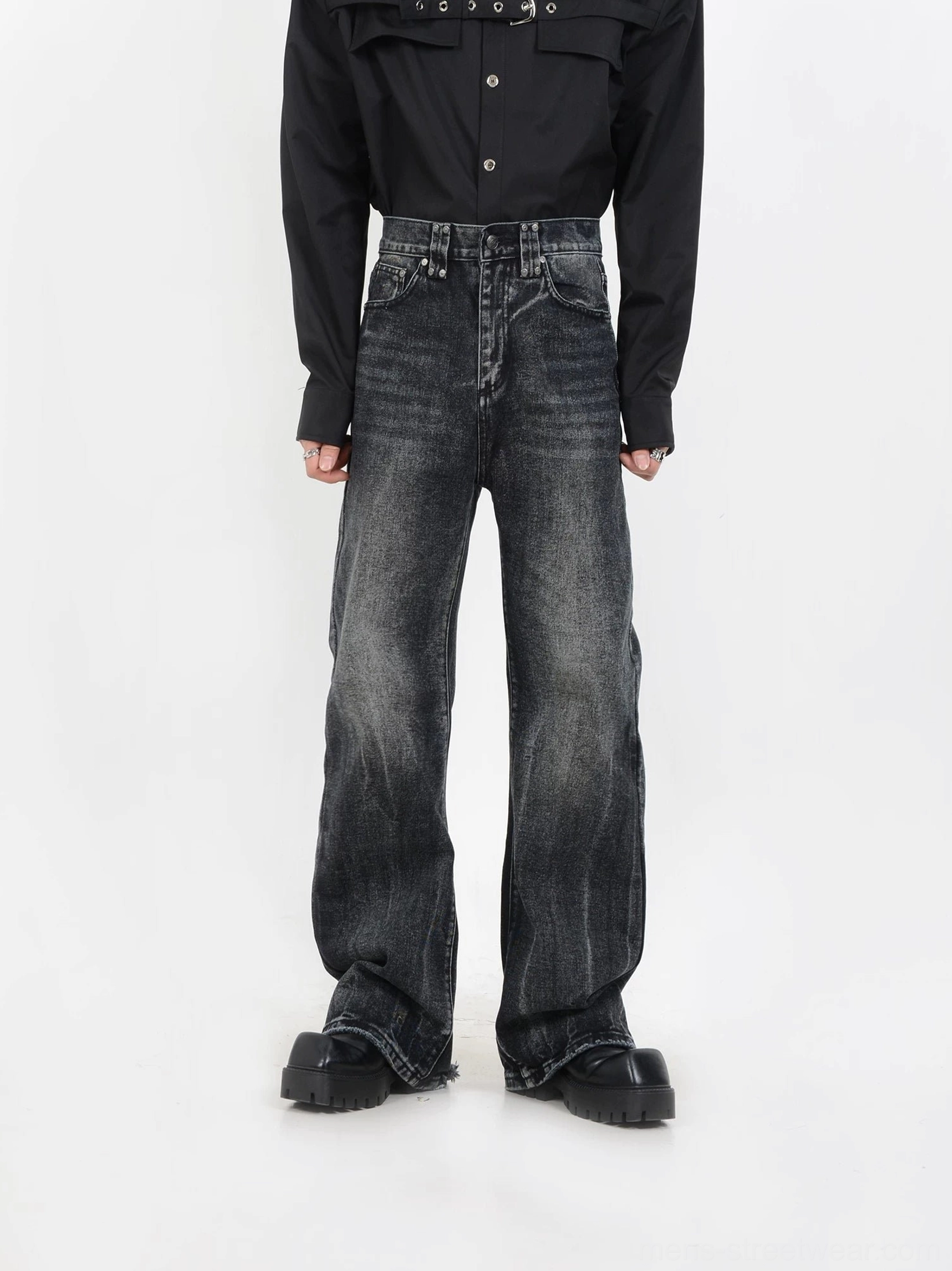 Full front view of black vintage wide-leg jeans with neat grey fading, structured waistband, stacked hem, and platform black boots