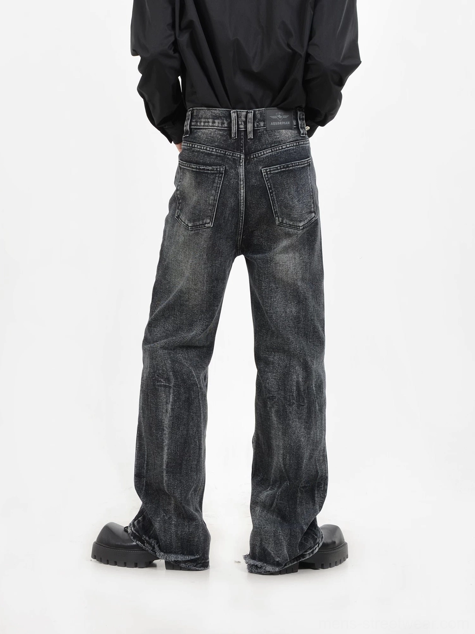 Rear view of faded black wide-leg jeans featuring two back pockets, belt loops, washed denim texture, and a modern streetwear fit