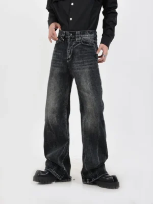Front three-quarter view of faded black wide-leg jeans showing button fly closure, vintage stone wash, relaxed Korean streetwear silhouette, and platform leather shoes