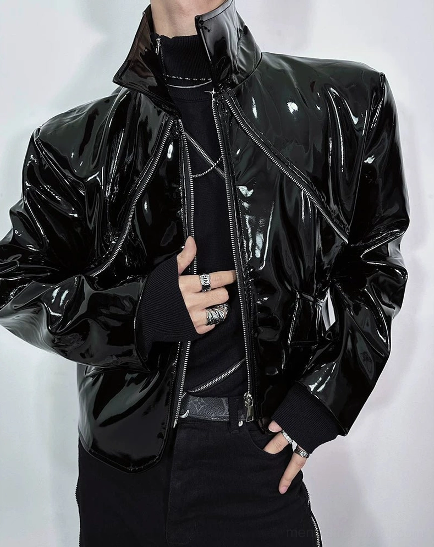 Side-front close-up of black glossy moto jacket with sculpted shoulder stand collar and silver jewelry styling
