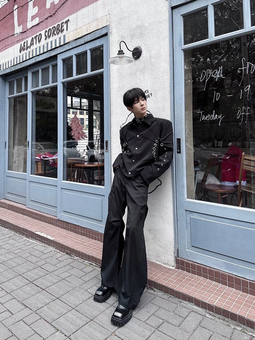 Black ultra-wide flare trousers worn with an all-black outfit against a gelato shop wall, showing sleek tailored fabric and relaxed Korean streetwear proportions