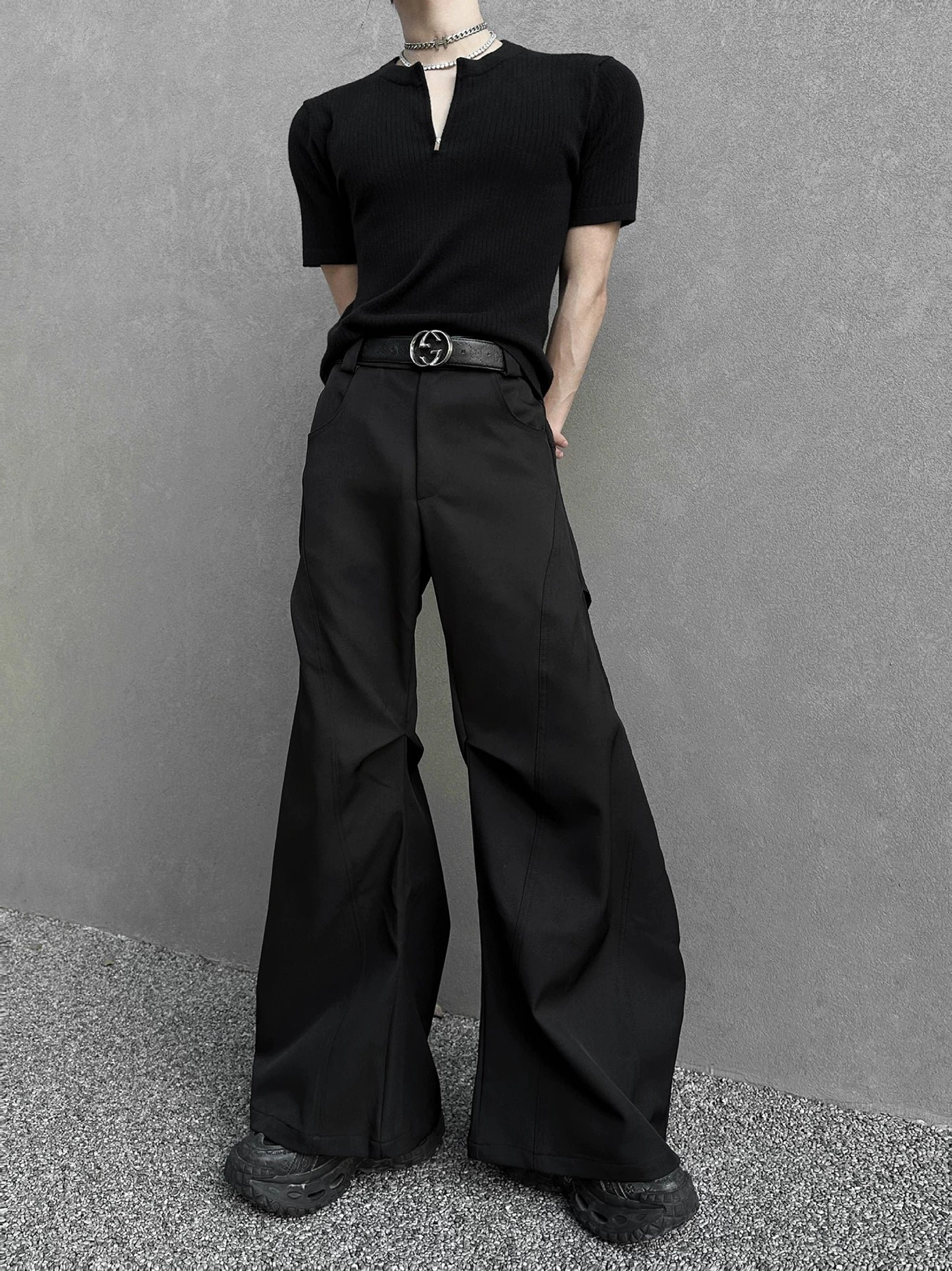 Front view of black hyperwide flare cargo trousers featuring clean tailored seams, high-waisted construction, exaggerated wide legs, leather belt, and Seoul streetwear styling