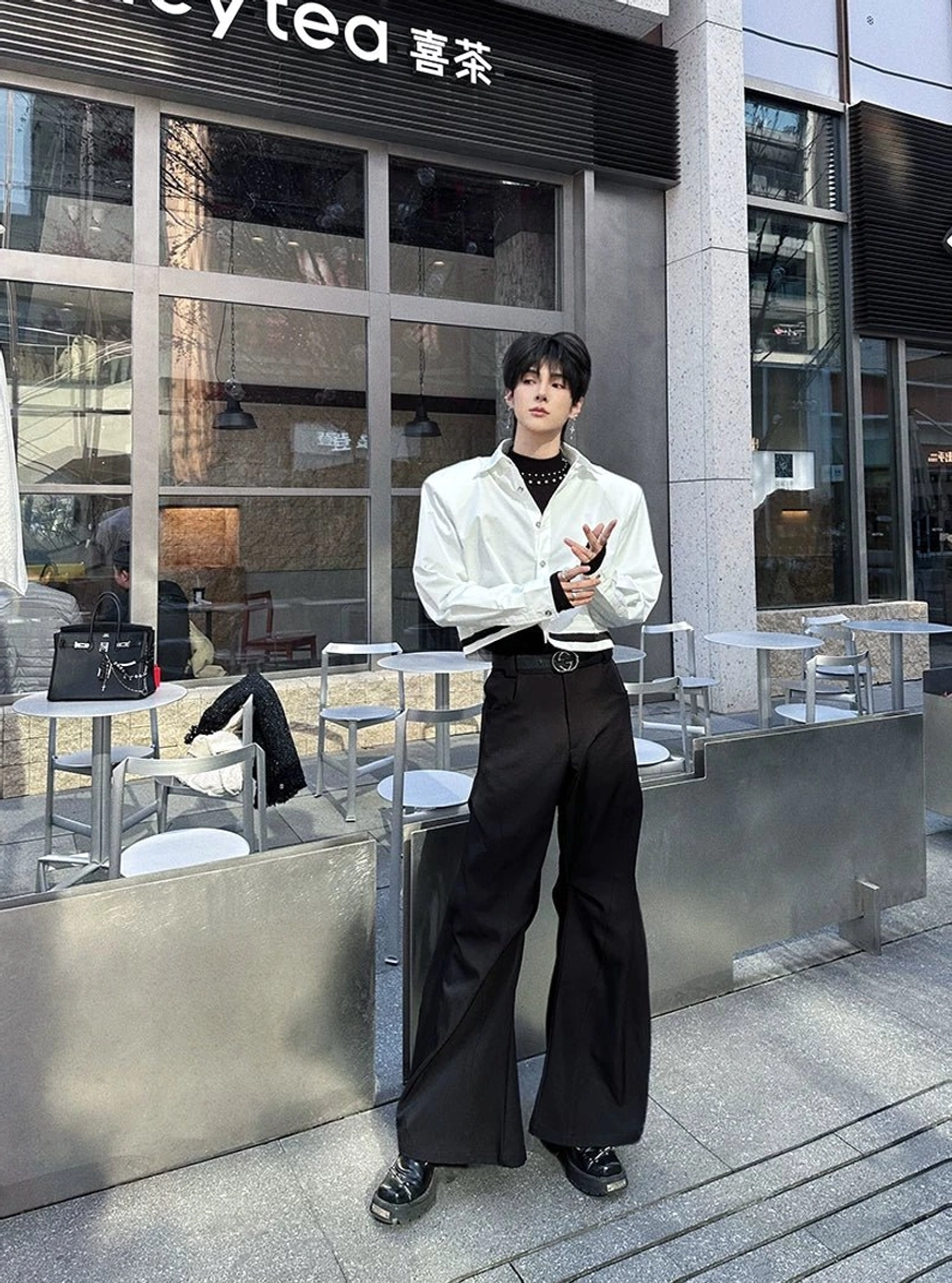 Black hyperwide flared tailored pants styled with a white shirt at a modern outdoor tea shop, highlighting clean seams and elevated Seoul fashion