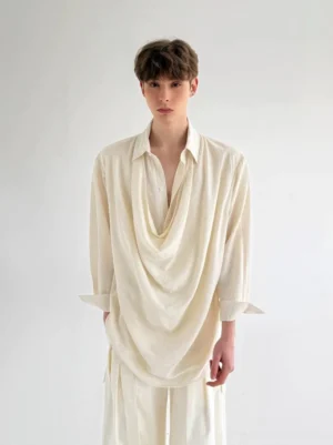 Close-up of men's off-white avant-garde shirt with pointed collar partial button placket and flowing draped front