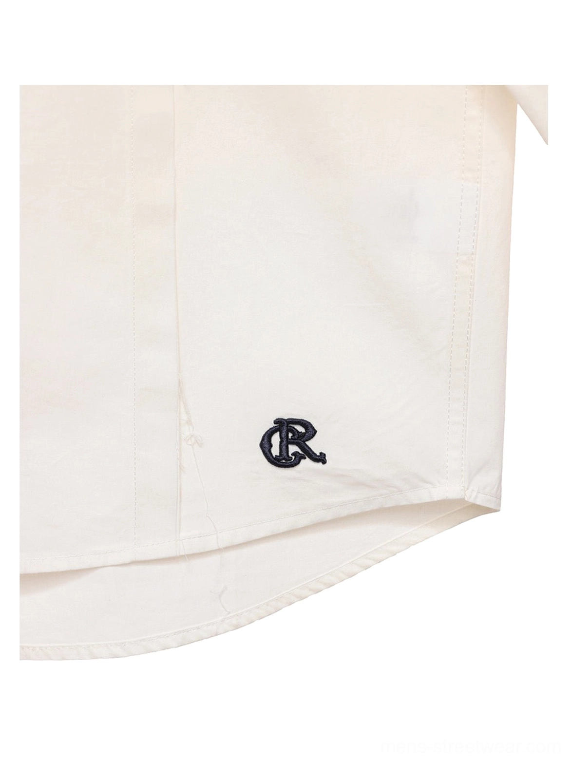 Close-up of adjustable button cuff and precise stitching on off-white cotton poplin long-sleeve overshirt
