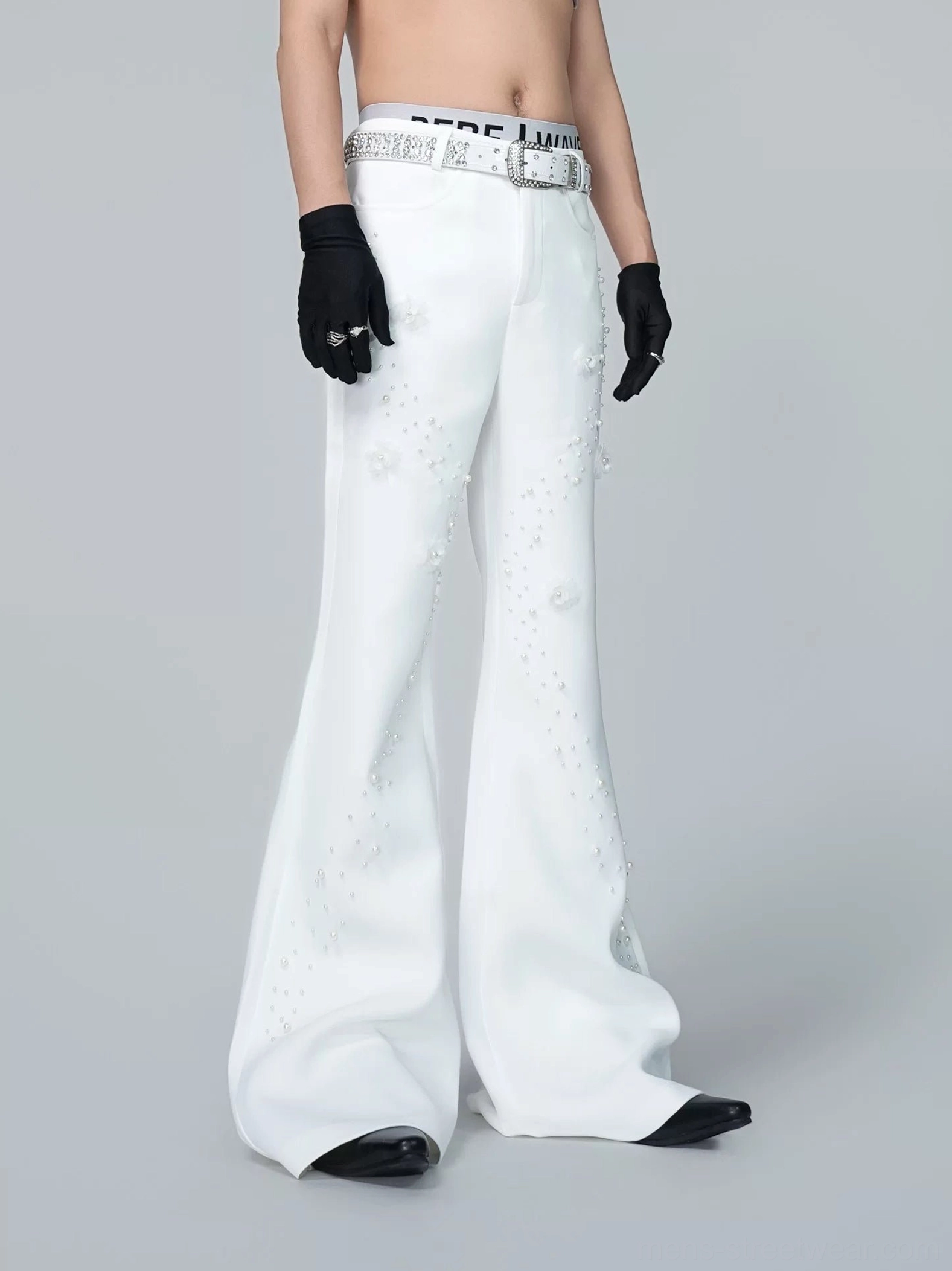 Straight front view of high-waisted off-white Korean streetwear flare trousers with pearl trails floral embellishments and decorative belt