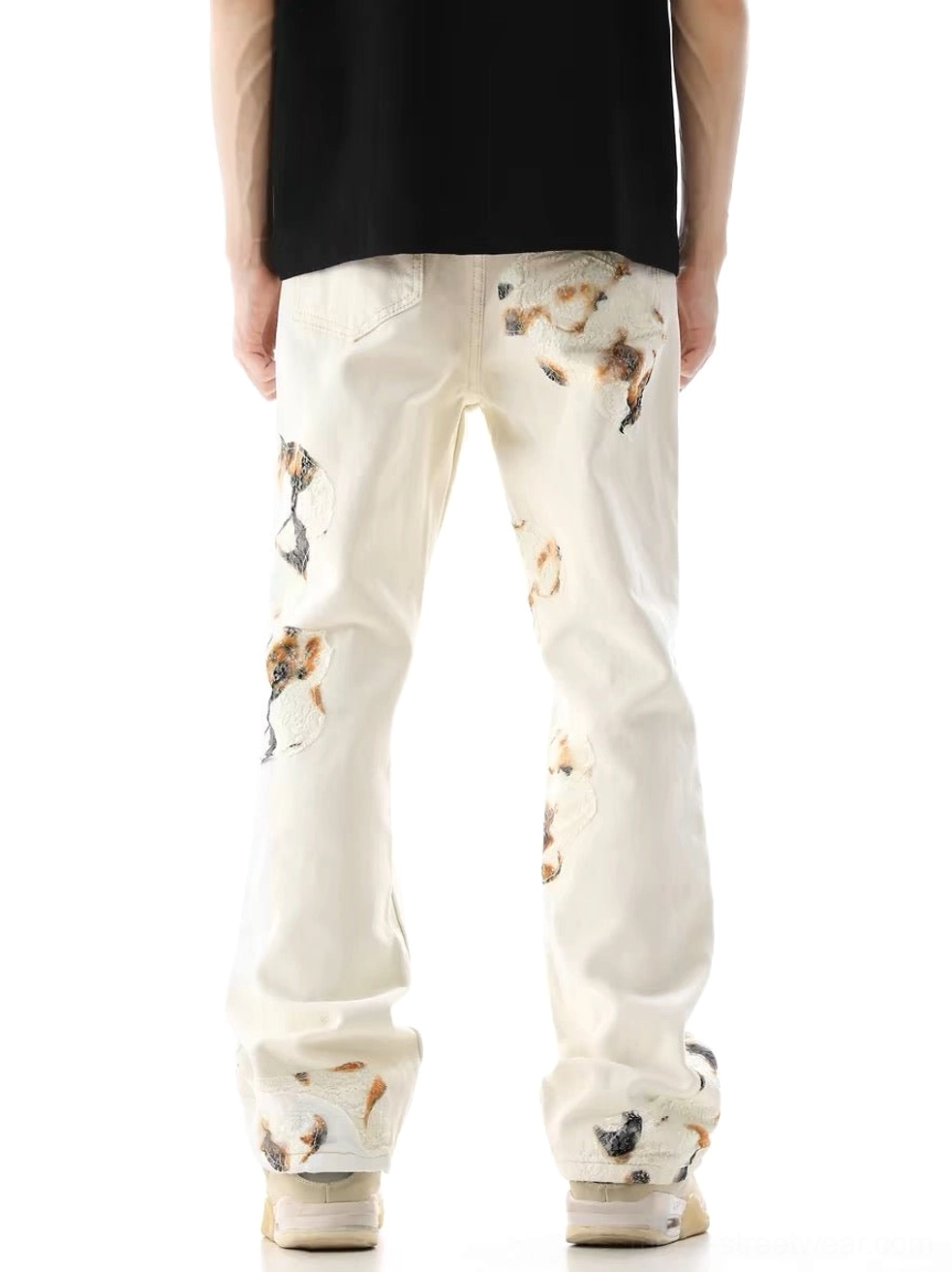 Back view of male model wearing off-white lace panel wide-leg denim jeans with patterned rear leg appliqué