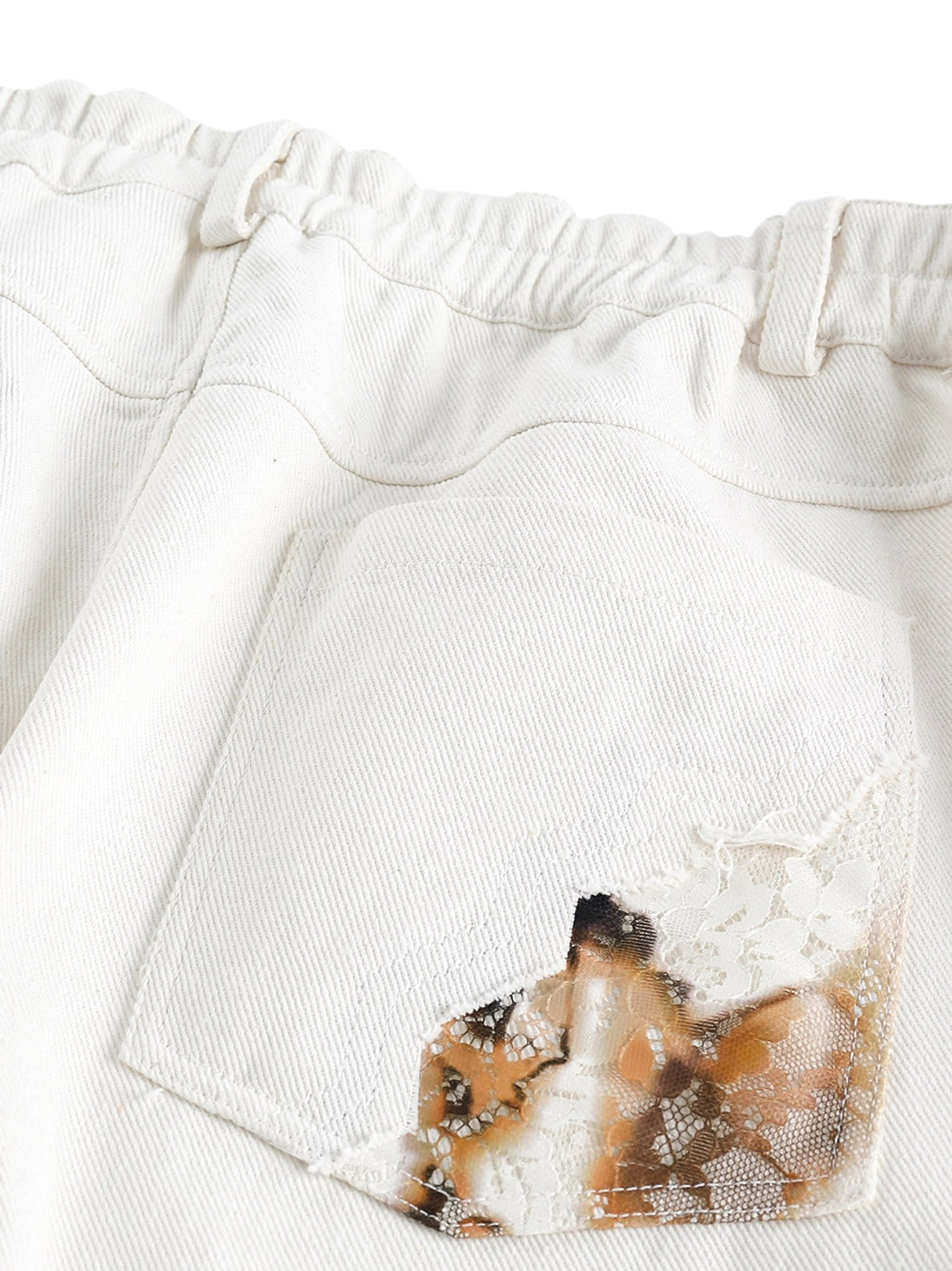 Rear pocket close-up of off-white lace panel wide-leg denim jeans with elastic back waist and patterned lace appliqué