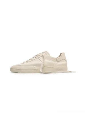 Off-white low-profile cowhide leather sneakers shown in a clean side view with a minimalist lace-up silhouette and flat streetwear design