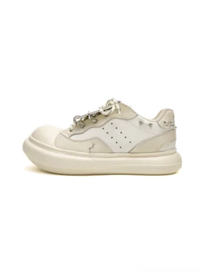 Off-white metal stud round-toe platform sneakers shown in a clean side view with perforated upper, chunky cream sole, and dual-tone woven laces