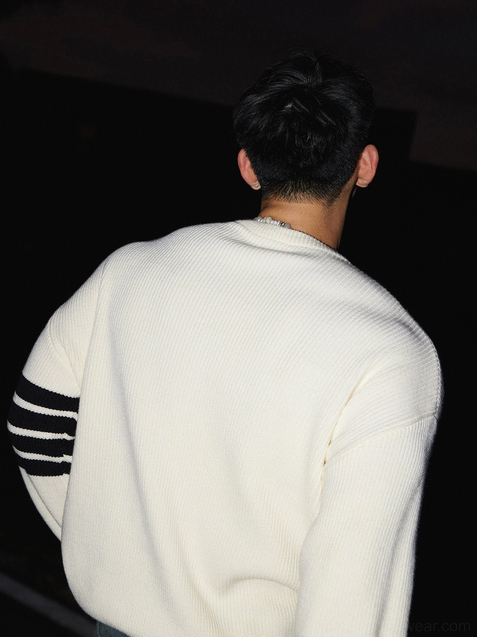 Back view of an off-white oversized Korean streetwear crewneck knit sweater with seamless back design, relaxed drop shoulders, and striped sleeves