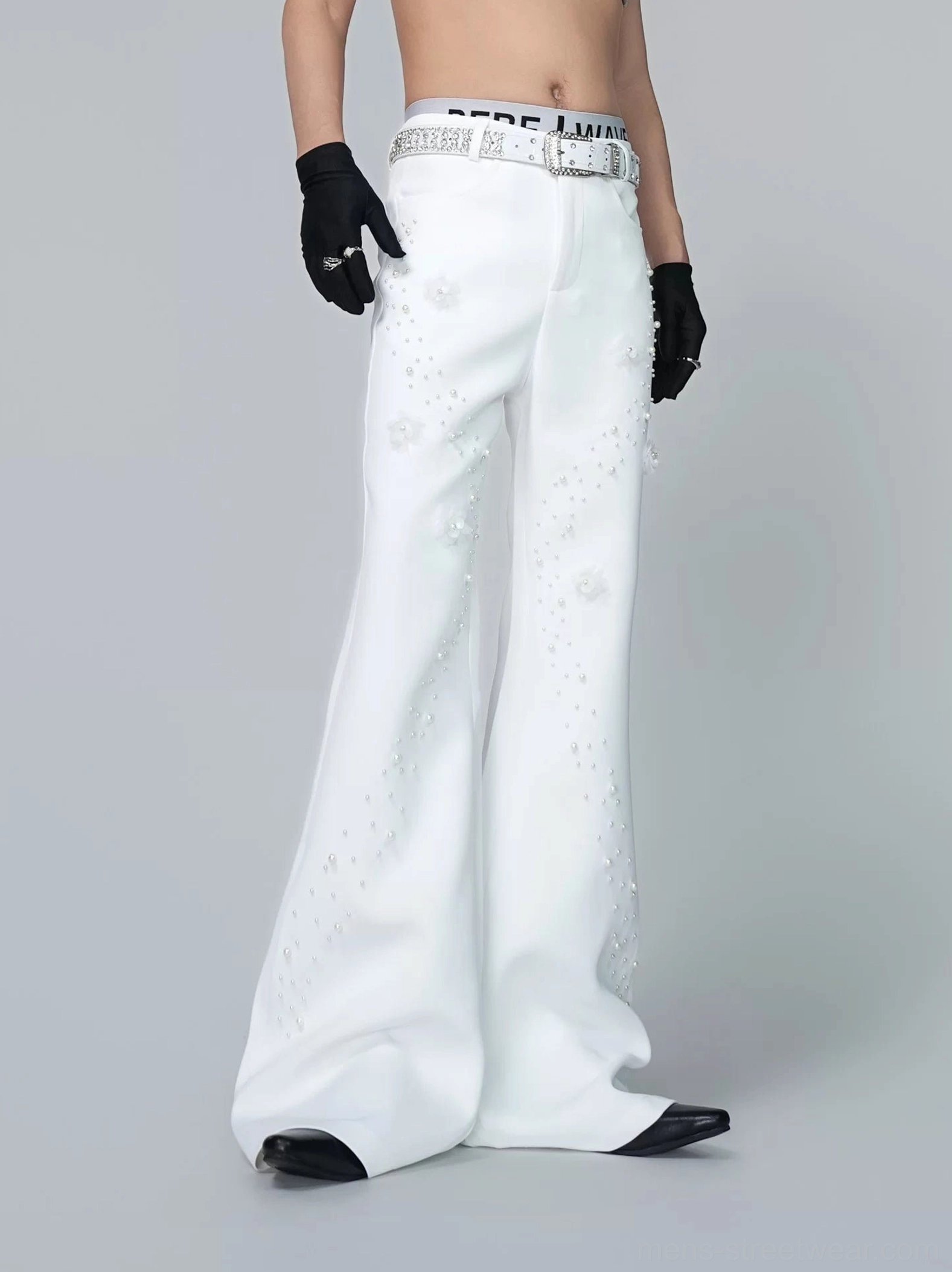 Front three-quarter view of off-white pearl embellished wide flare trousers with 3D floral appliques and matching rhinestone-style belt