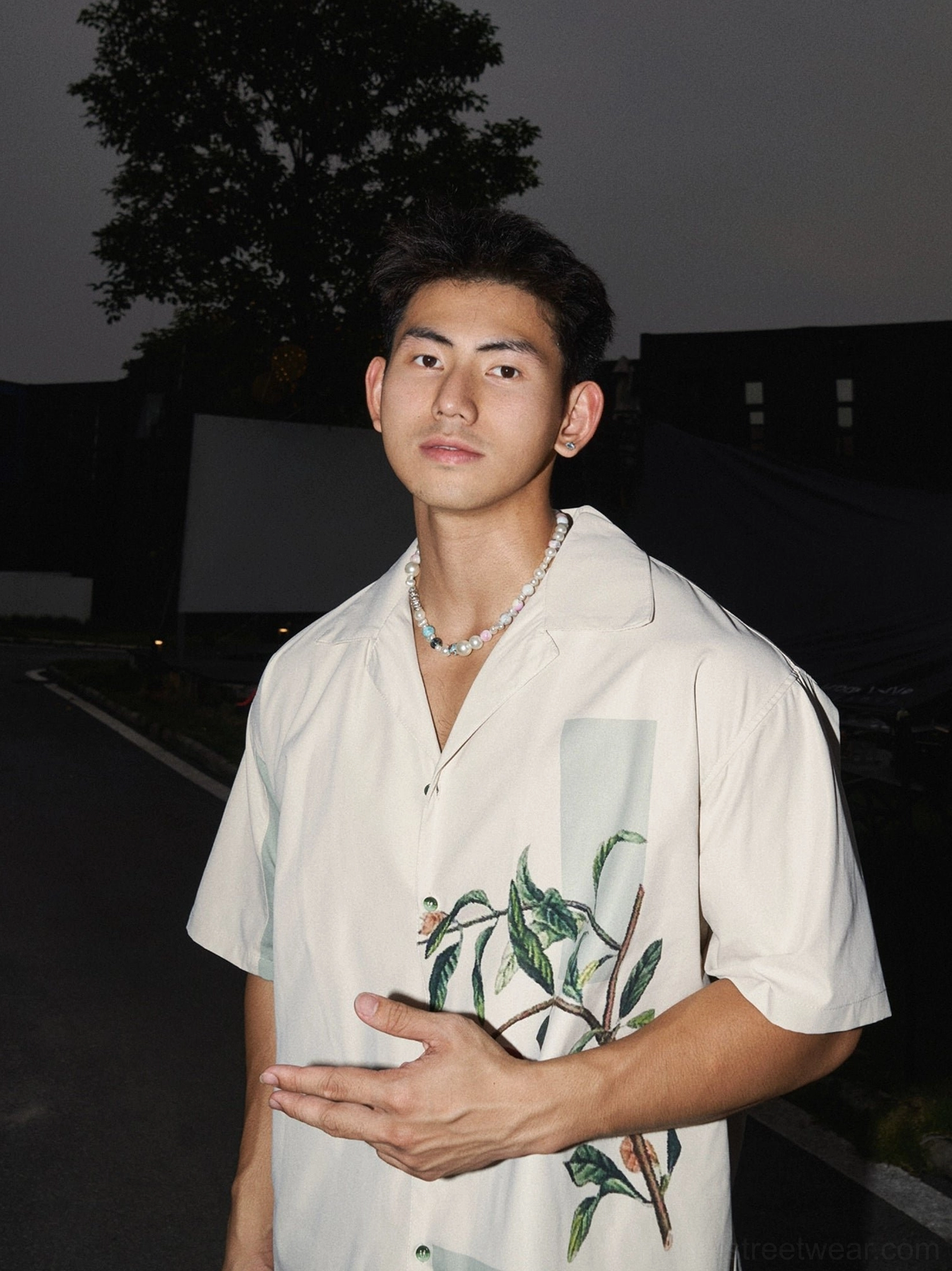 Front close-up of a relaxed off-white botanical print camp shirt with pomegranate branch artwork and smooth woven texture