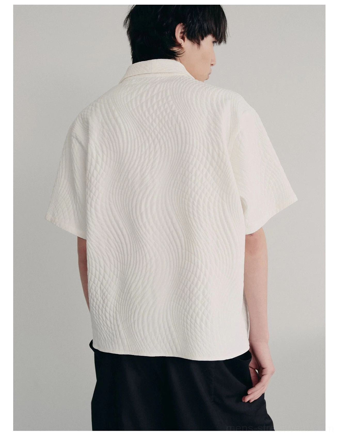 Back view of off-white quilted camp collar shirt showing full wave texture relaxed sleeves and loose fit