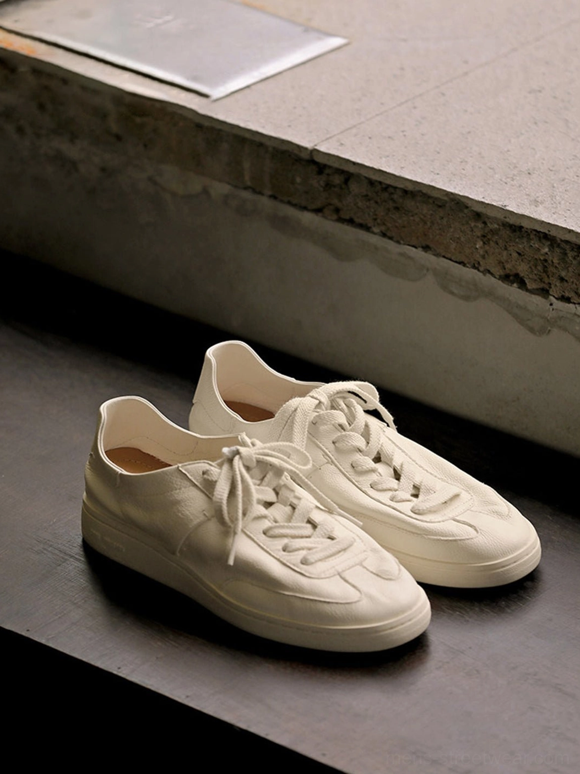 Two pairs of off-white retro cowhide leather sneakers displayed side by side with rounded toe caps and minimalist styling