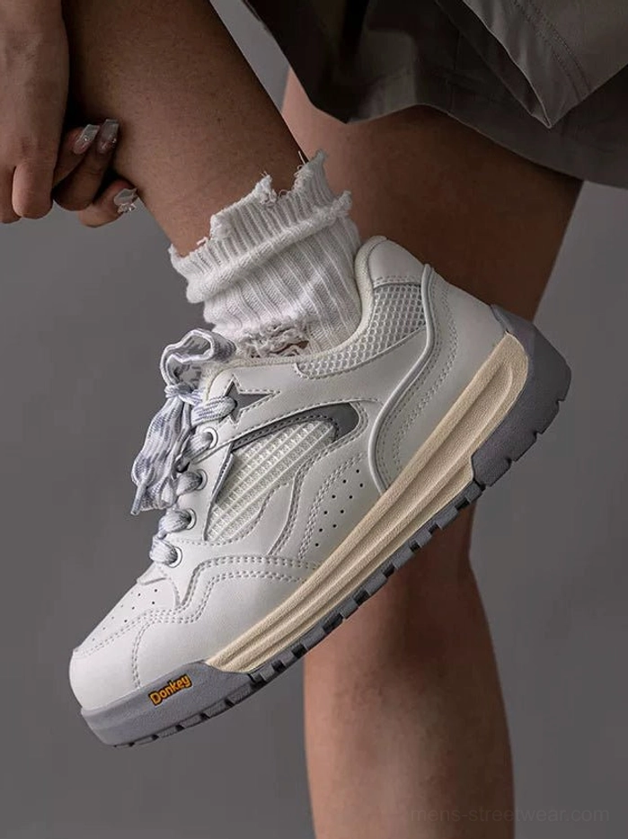Close-up of off-white retro runner sneaker worn with frilly white crew socks showing breathable mesh panels and thick sole