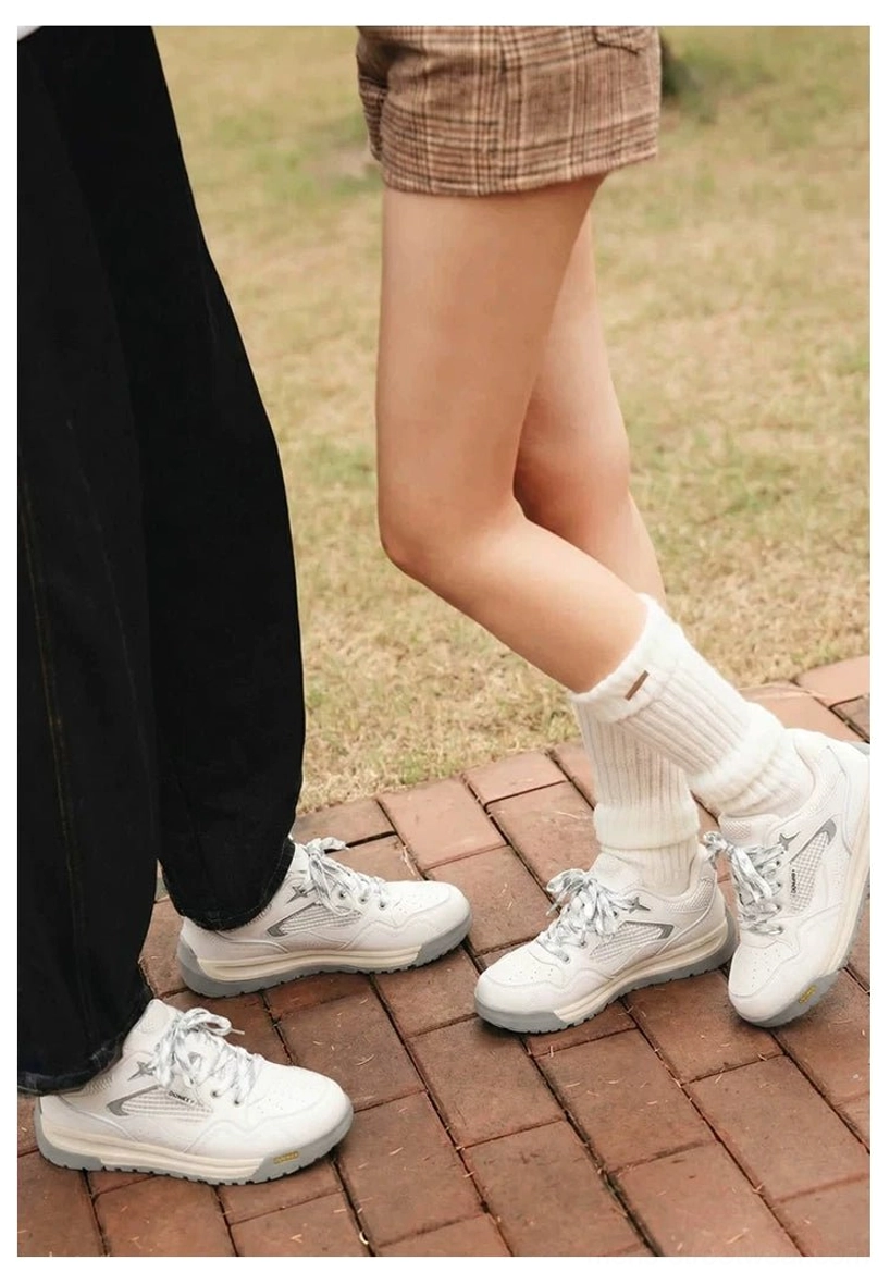 Two pairs of off-white retro runner sneakers worn with white crew socks on outdoor brick pavement and green lawn
