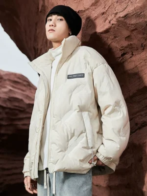 Off-white rhombus quilted duck down puffer jacket shown from the front three-quarter view with stand collar chest patch label zip pockets and adjustable hem