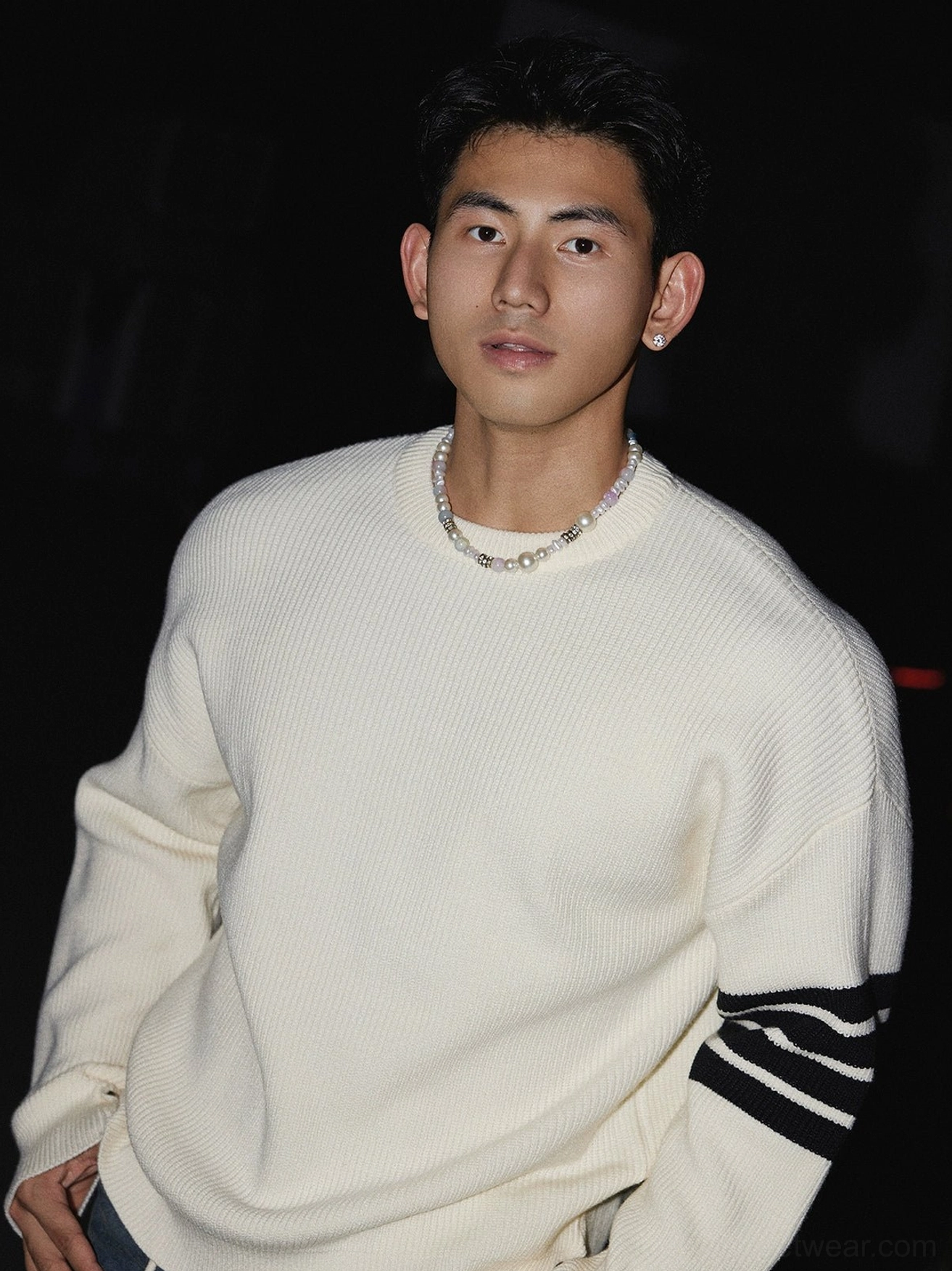 Close-up of an off-white ribbed knit crewneck sweater with triple black sleeve stripes and soft textured Korean streetwear styling