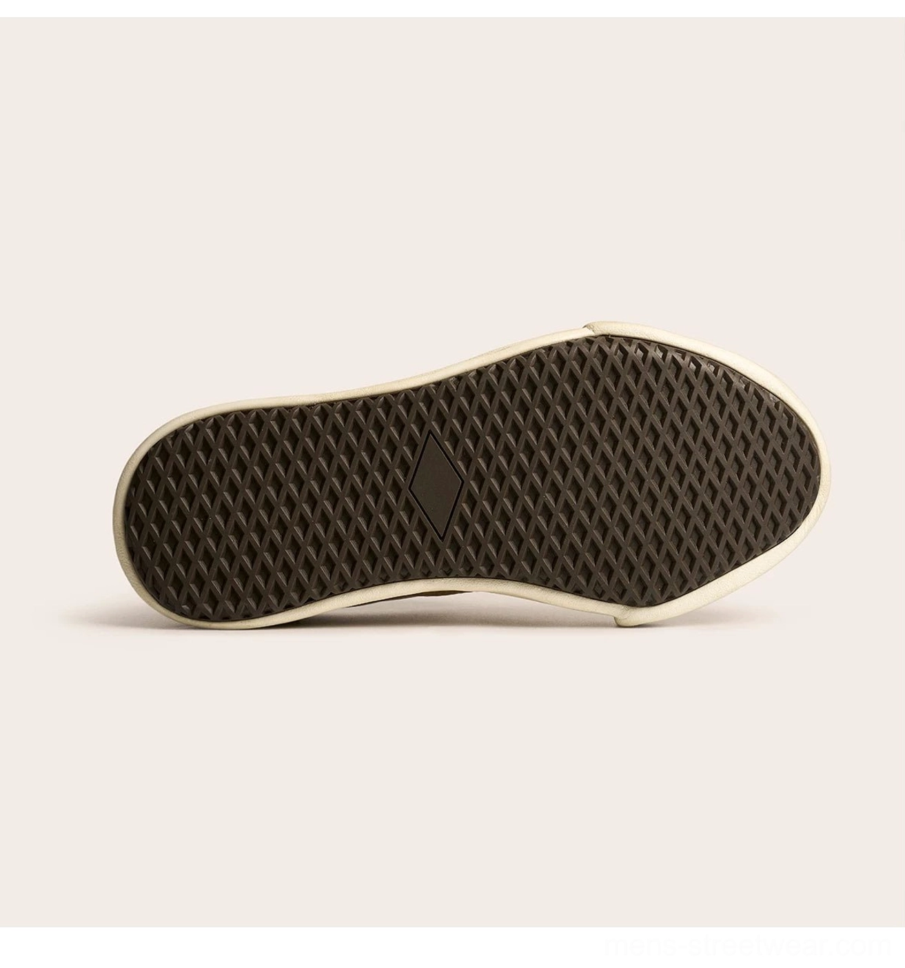 Close-up flat view of the off-white rubber sneaker outsole with waffle anti-slip tread pattern and embossed central logo detail