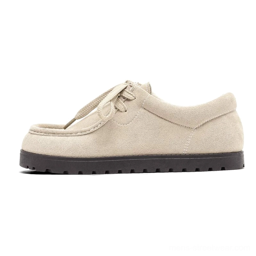 Off-white suede square-toe lace-up casual shoes with low-profile shape and thick black ridged outsole on a studio background