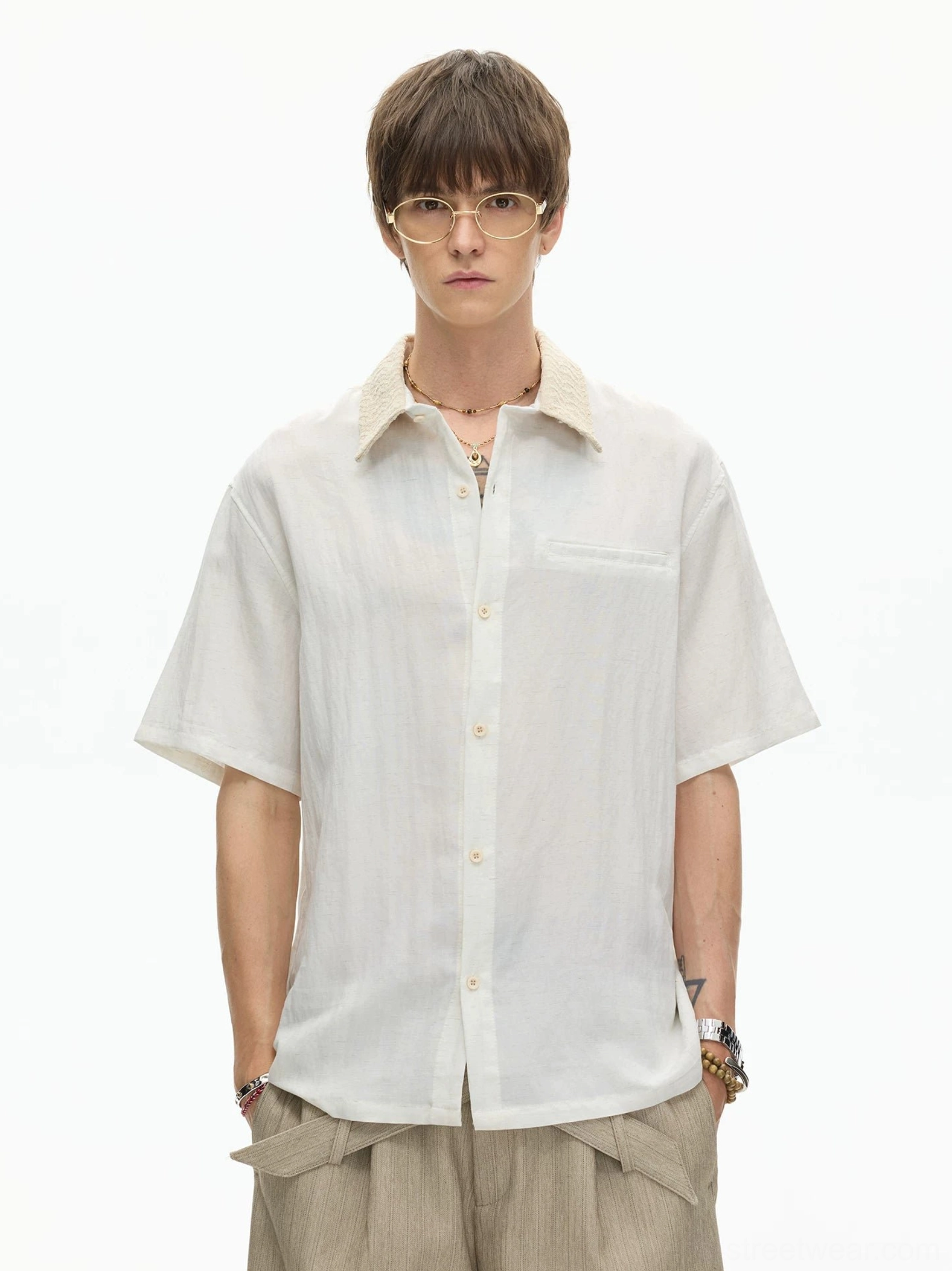 Off white textured camp collar shirt with button front and chest pocket worn with beige wide leg pants