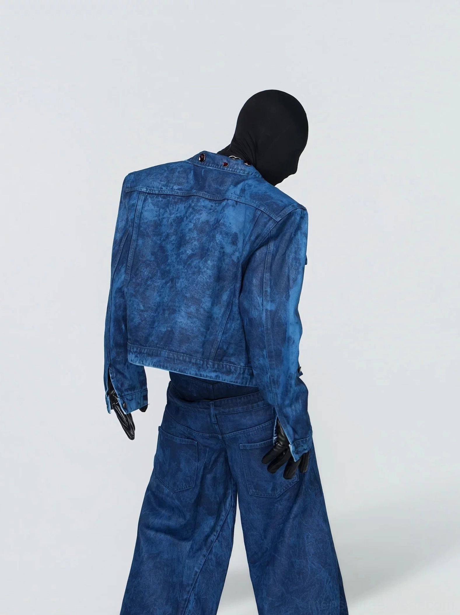 Rear three quarter view of the oil wax blue marble wash cropped denim jacket showing classic back yoke and structured trucker silhouette