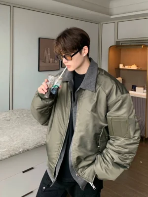 Olive green oversized zip bomber jacket with grey contrast collar layered hem and sleeve utility pocket shown in side streetwear styling