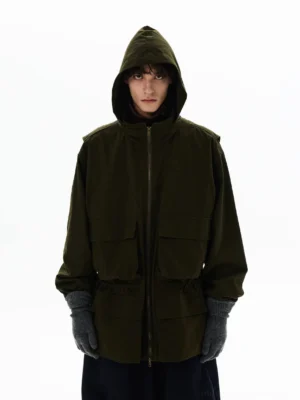 Olive green oversized hooded utility parka shown with full zipper, cargo pockets, heavy-duty outer fabric, and modern techwear styling