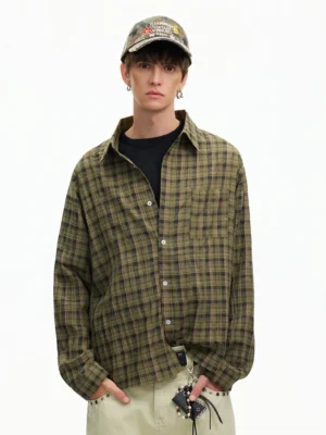 Male model wearing an olive green oversized plaid flannel shirt with black tee khaki pants and camo cap in a Korean streetwear outfit