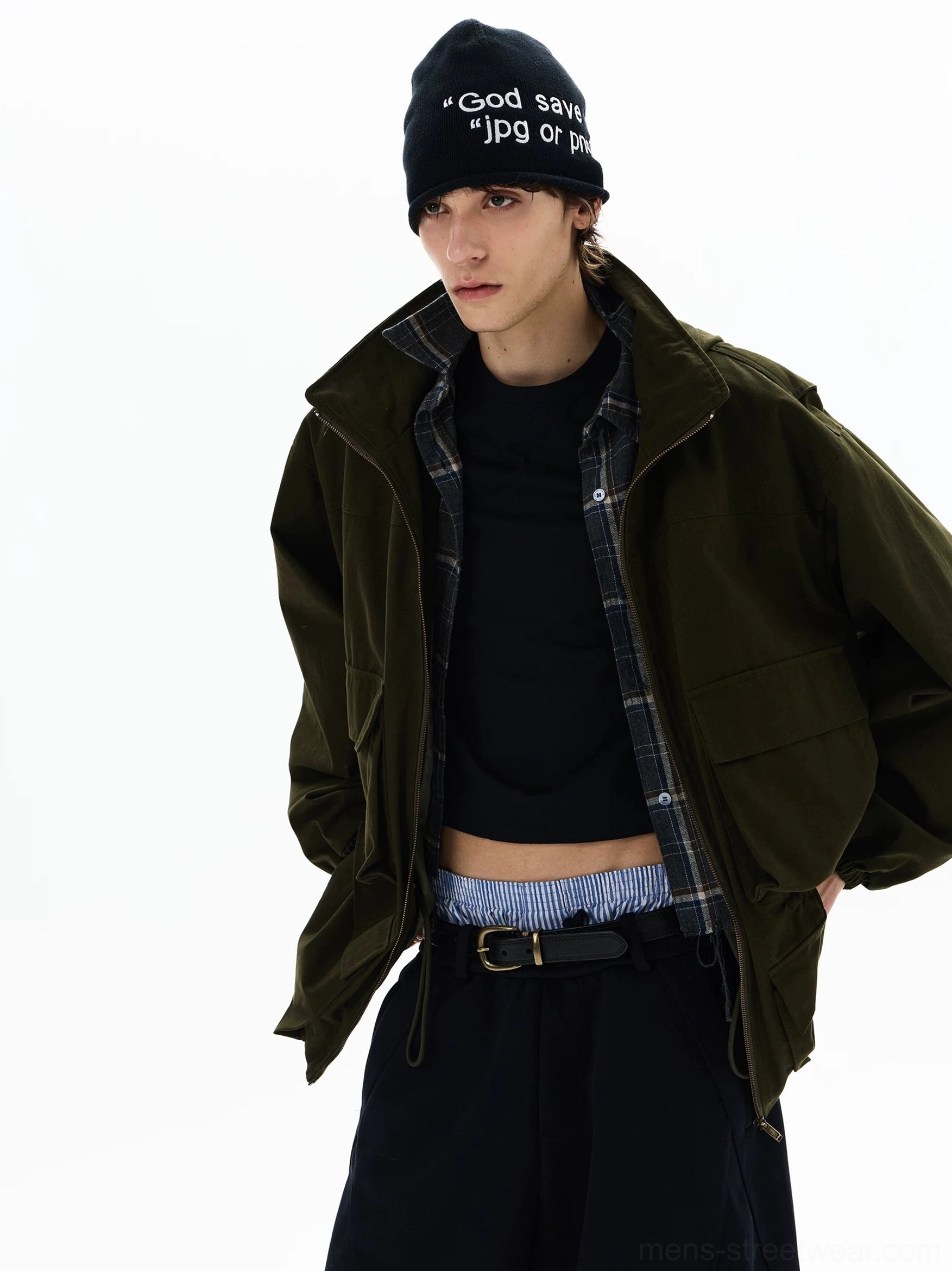 Three-quarter view of an olive green oversized zip parka with exposed plaid lining, stand collar, cropped inner layer, and wide-leg styling