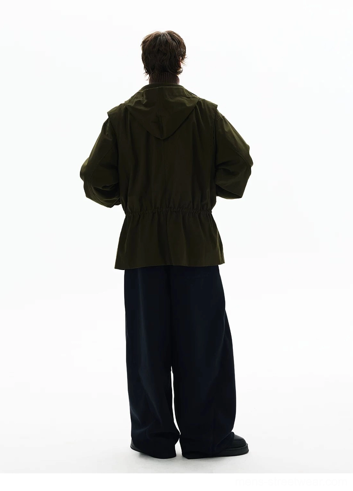 Back view of an olive green oversized utility parka showing attached hood, loose sleeves, clean back panel, and adjustable rear waist drawstring