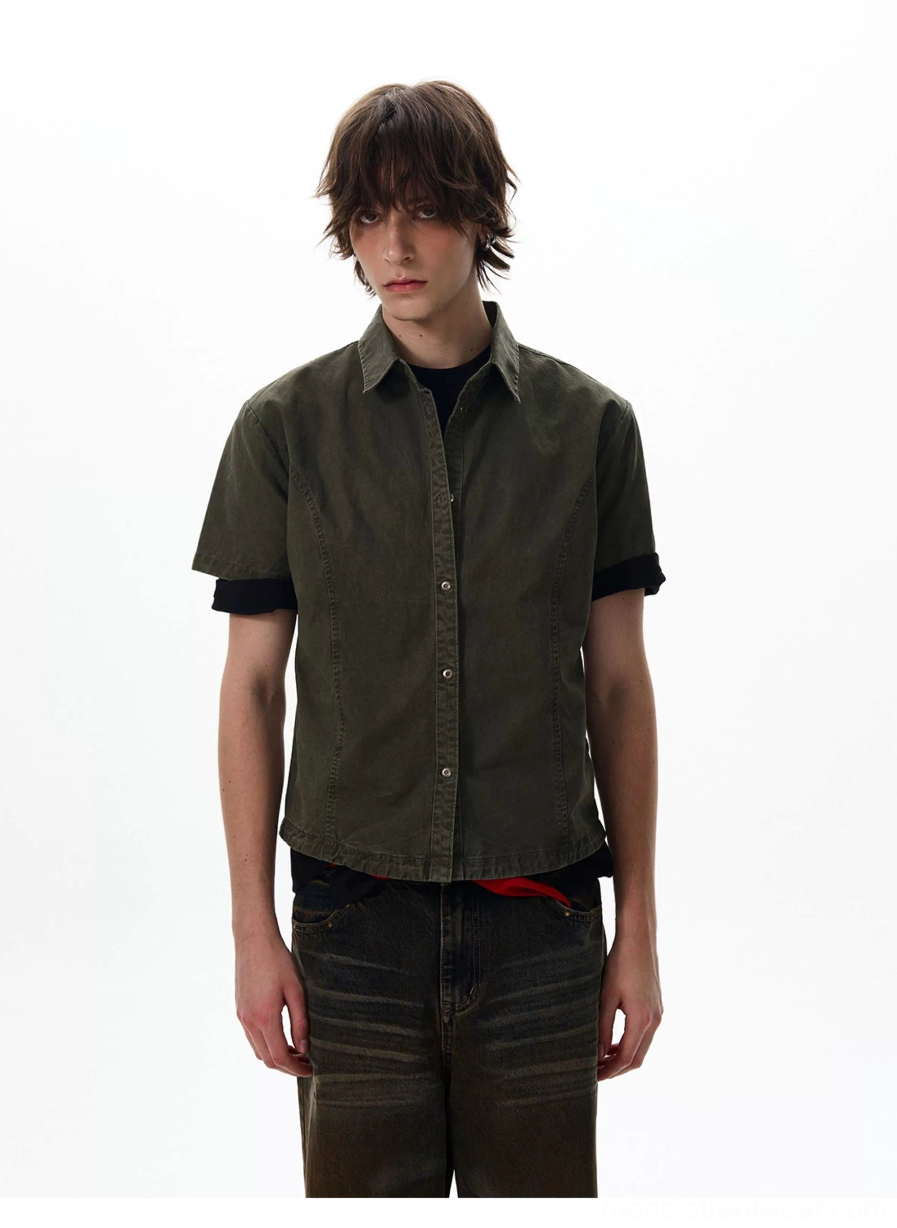 Close front view of olive green utility shirt showing button placket and contrasting black sleeve cuffs