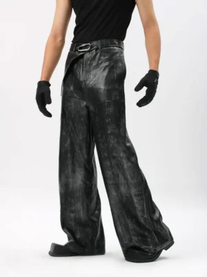 Front three-quarter view of black Onyx Mirage distressed wide-leg trousers with coated brushed texture and metal buckle belt styling