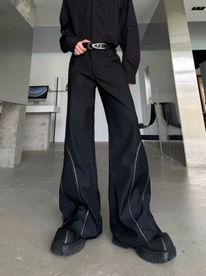 Black Orbit Sculpt high-waisted wide-leg trousers shown in a lower-body front close-up with silver outer-leg zippers, curved seams, and a matching leather belt