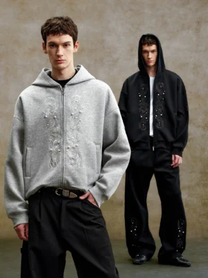 Black and heather gray ornate pearl embroidered boxy zip-up streetwear hoodies worn by male models with wide-leg trousers