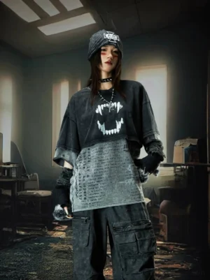 Female punk model wearing an oversized washed black acid-wash fangs graphic tee with layered hem and wide sleeves