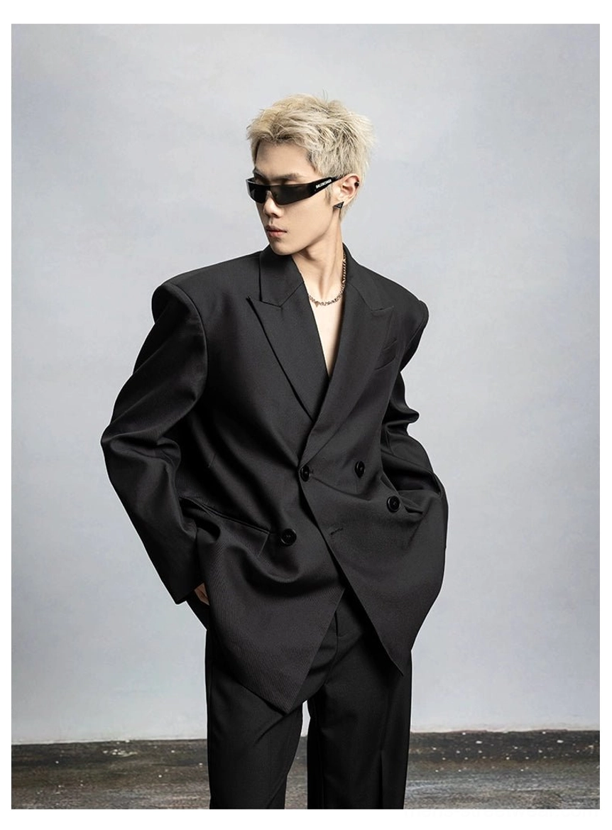 Relaxed oversized black double-breasted blazer silhouette photographed from the side in a neutral studio