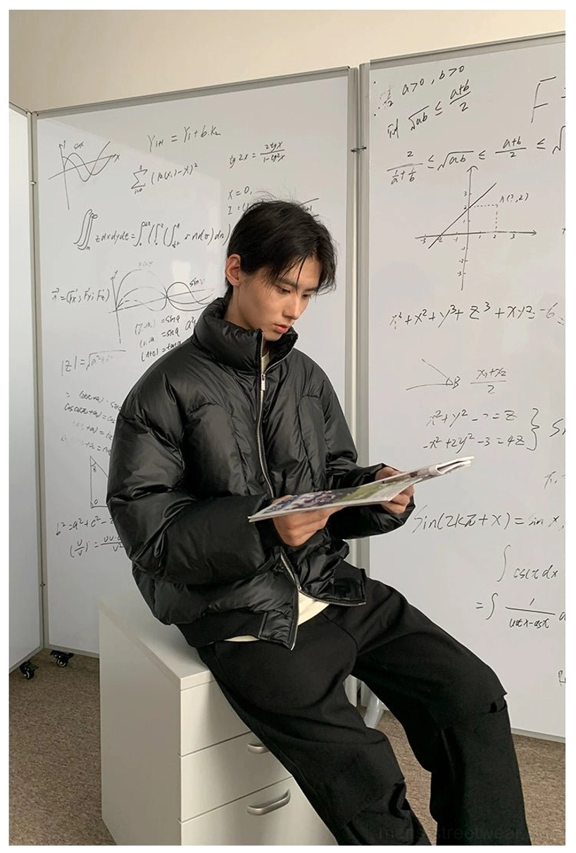Side view of oversized black duck down puffer jacket showing relaxed boxy fit and glossy quilted construction