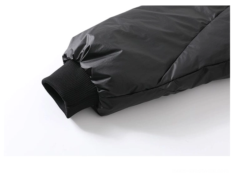 Close-up sleeve view of black duck down puffer jacket showing quilted nylon fabric and ribbed knit cuff
