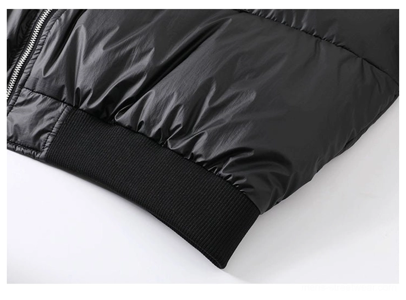 Close-up of glossy black nylon puffer jacket hem with ribbed waistband and front zipper detail