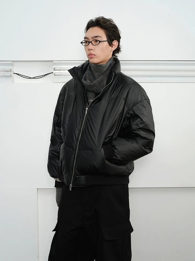 Oversized black duck down puffer jacket with stand collar and glossy quilted nylon front view on male model