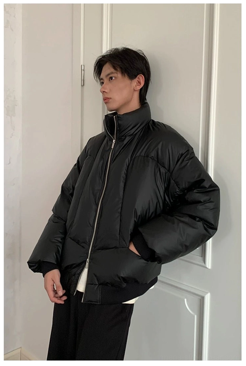 Side profile of black oversized duck down puffer jacket with stand collar full zipper and relaxed casual silhouette
