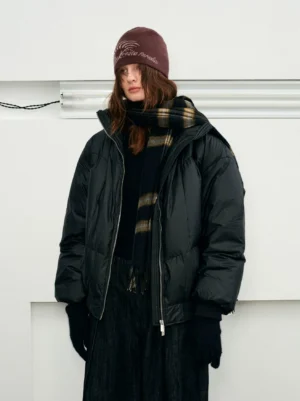 Black oversized duck down puffer jacket styled with knit beanie and plaid scarf in a full body winter streetwear outfit