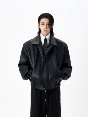 Oversized black faux leather bomber jacket front full body view on model in white studio