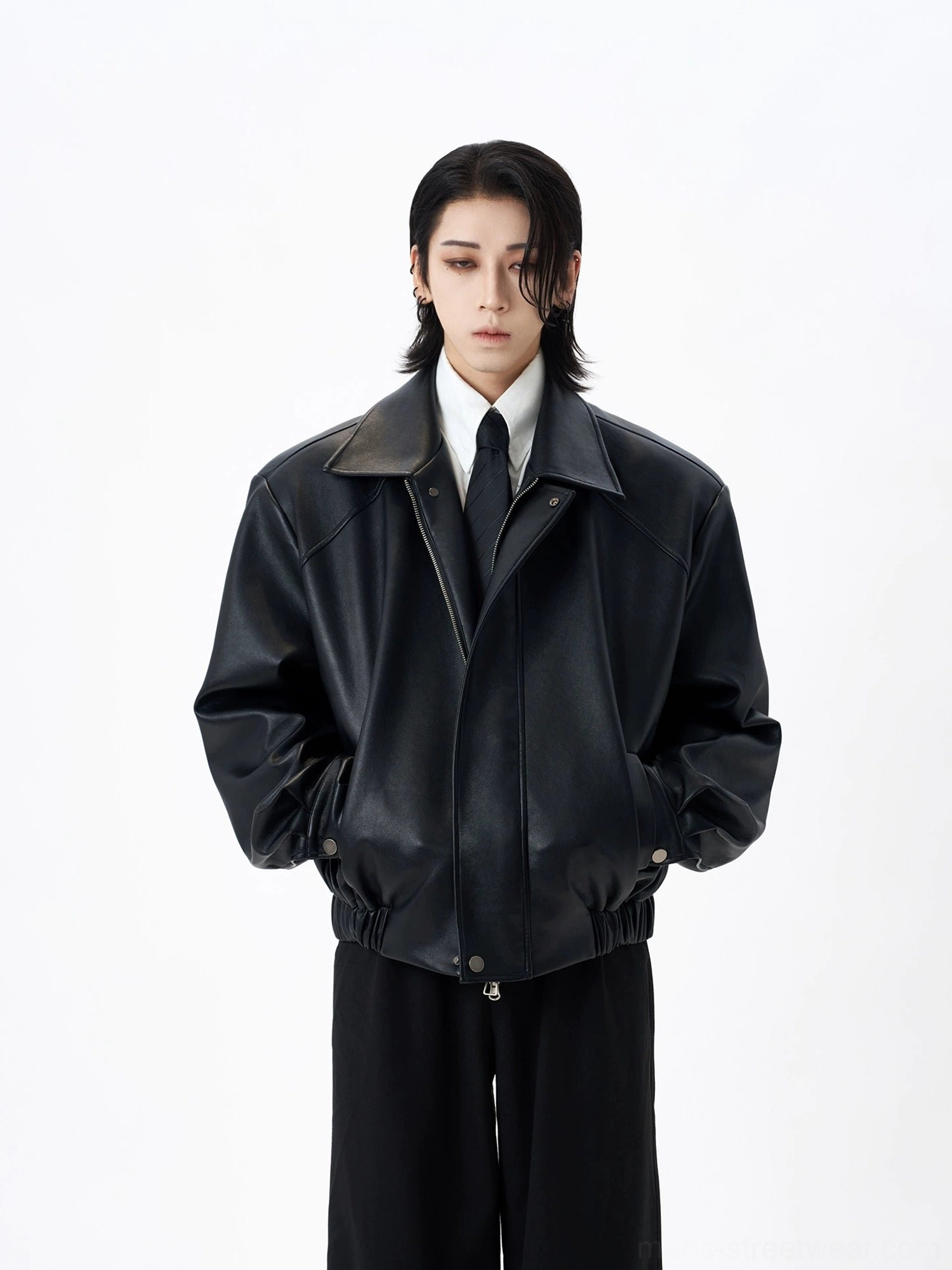 Oversized black faux leather bomber jacket front full body view on model in white studio
