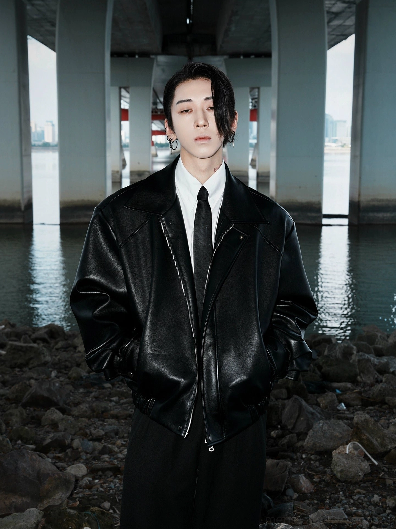 Oversized black faux leather bomber jacket all black streetwear outfit by riverside bridge