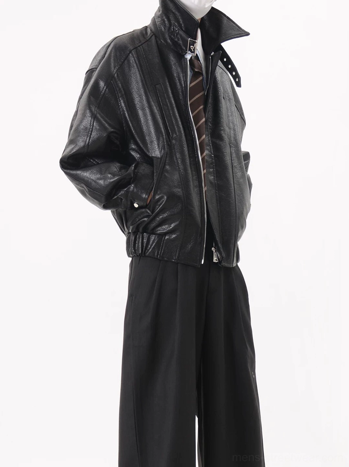 Black oversized faux leather buckle collar zip-up bomber jacket shown in left three-quarter view with shirt tie and wide-leg trousers