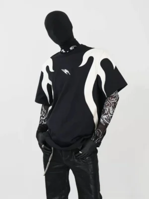 Left three-quarter front view of an oversized black flame panel T-shirt with off-white flame appliques, drop shoulders, tattoo mesh sleeves, black gloves, leather pants, and cyberpunk streetwear styling