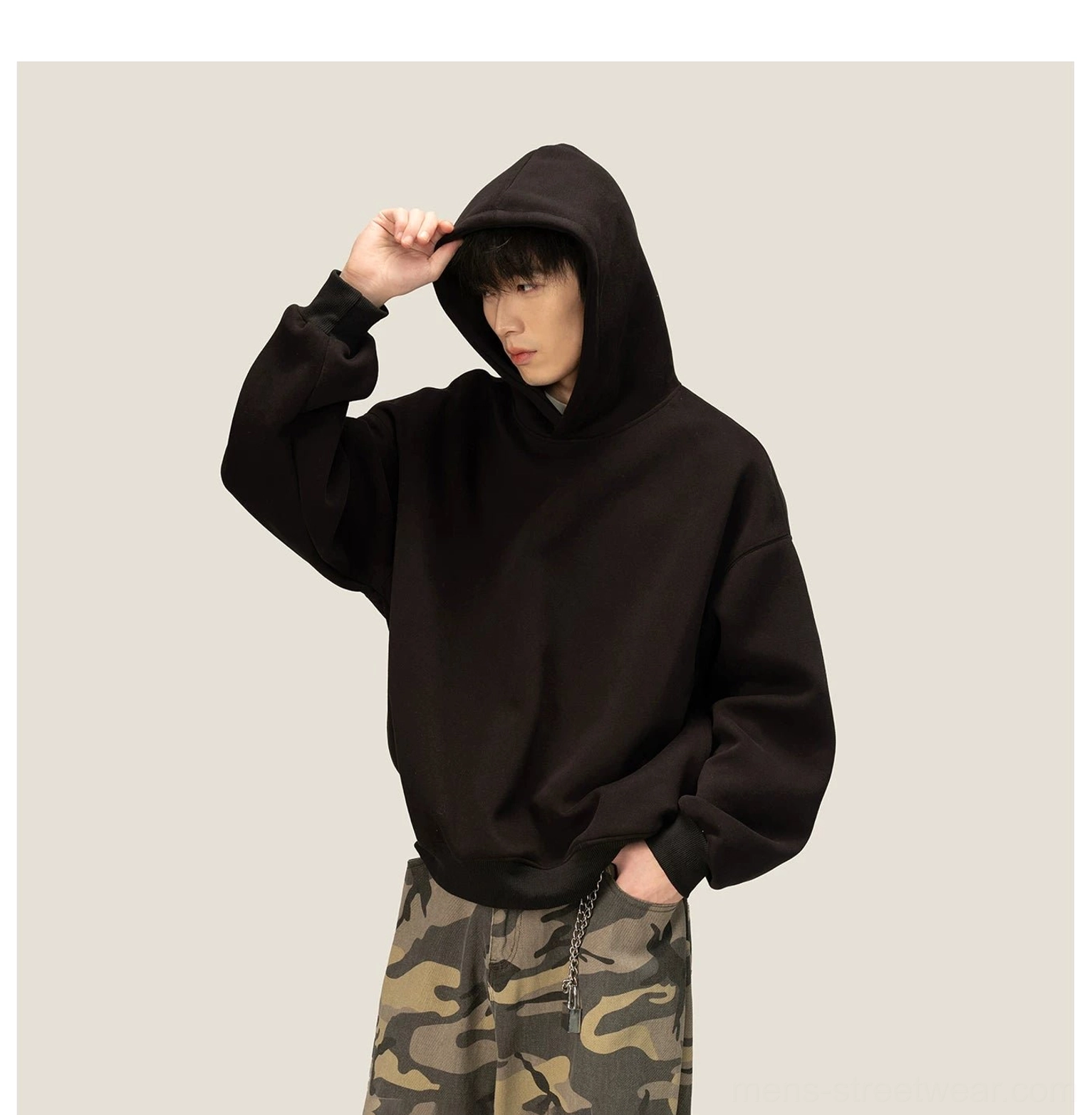 Oversized black fleece hoodie worn with the hood up showing relaxed loose Korean streetwear styling